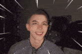 a young man with a shaved head is smiling and wearing a tie .