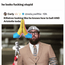 a tweet from carly shows a man in a suit and tie holding a statue