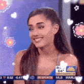 ariana grande is smiling in front of a good morning america banner