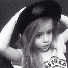 a little girl wearing a hat and a t-shirt with the word felka on it