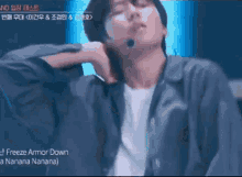 a man wearing a microphone and a jacket is singing freeze armor down