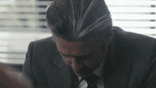 a man in a suit and tie looks down