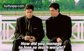 two men in suits are sitting next to each other on a bench talking to each other .