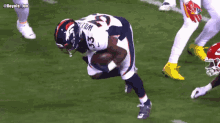 a football player with the number 33 on his jersey runs with the ball