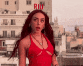 a woman in a red dress is standing in front of a building that says riu