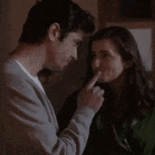 a man and a woman are touching each other 's hair