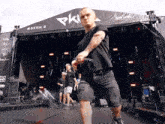 a man stands on a stage in front of a pk banner