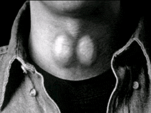 a close up of a man 's neck with a black shirt on