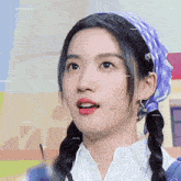 a close up of a woman wearing pigtails and a bandana