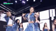 a group of women are dancing on a stage with the words the show visible in the background