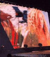 a large screen shows a picture of a woman on it
