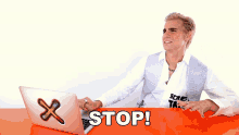 a man sitting at a desk with a laptop and a sign that says stop on it