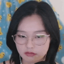 a woman wearing glasses and headphones is making a funny face .