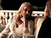 a woman is sitting on a couch talking to another woman and says you can 't get close