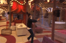 a man is dancing in a room with a red curtain behind him