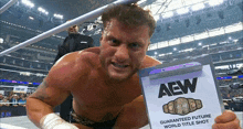 a wrestler is holding a clipboard that says aew