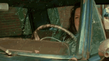 a woman is driving a car with a steering wheel that says ' a ' on it