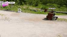 a sign that says 1 round is on the side of a dirt road