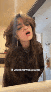 a girl is singing a song in front of a mirror