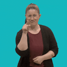 a woman wearing glasses and a red shirt is pointing her finger at the camera