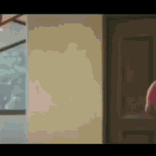 a person is standing in a room next to a door and a window .
