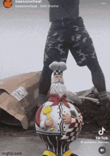 a person is standing on a statue of a chef with a chef 's hat on