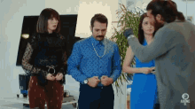a group of people are standing in a room with a sign that says ' abone ol ' on the bottom