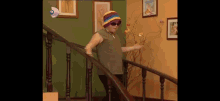 a woman wearing a hat and sunglasses is walking down a set of stairs