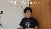 a man wearing a shirt that says los pollos is standing in front of a wall that says fetch catch