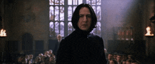 a man in a black coat stands in front of a group of people