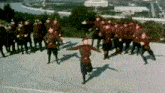 a group of soldiers are dancing on a street in front of a city .
