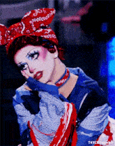 a drag queen wearing a red bandana and a choker