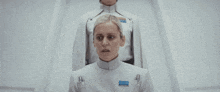 a woman in a white uniform is being shaved by a man in a white uniform