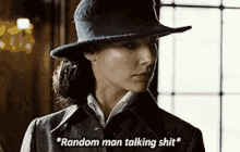 a woman wearing a hat and a coat is talking to a man .