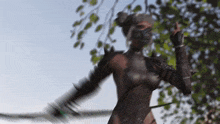 a naked woman in a warrior costume is holding a sword in her hand .