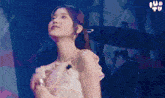 a woman in a pink dress is singing into a microphone on stage