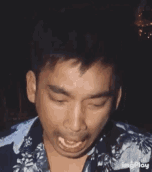 a close up of a man making a funny face with his mouth open .