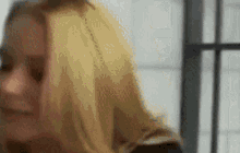 a close up of a woman 's face in front of a window with a blurry background .
