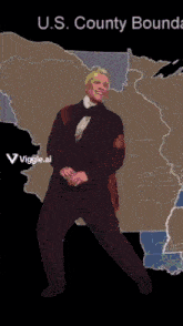 a man in a suit stands in front of a map of the u.s. county boundary