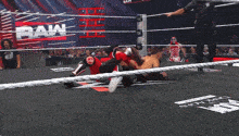 two wrestlers in a wrestling ring with the word raw on the ropes