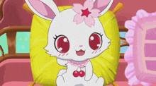 a cartoon rabbit with a pink flower on its head is sitting on a yellow pillow