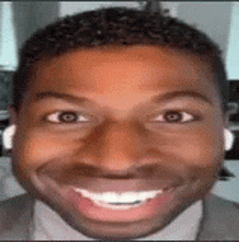 a close up of a man 's face with headphones on and smiling .