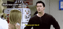 a man is talking to a woman in front of a refrigerator and says i 'm curvy and i like it .