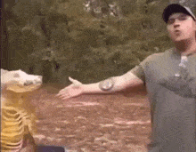 a man is standing in the woods with his arms outstretched and a bag of chips in front of him .