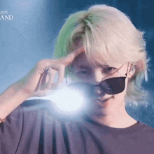 a man with blonde hair is wearing sunglasses and making a funny face