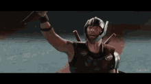 a man in a helmet is holding a sword in his hand .