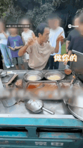 a man in a guess shirt is standing in front of a food stand