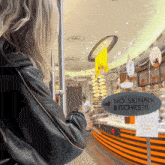 a woman standing in front of a store with a sign that says " no skinny bitches "