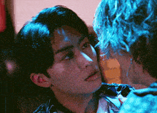 a close up of a person 's face with a blue light behind them