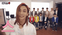 a group of young men are posing for a picture and one of them is wearing a white shirt with a pink letter s on the front